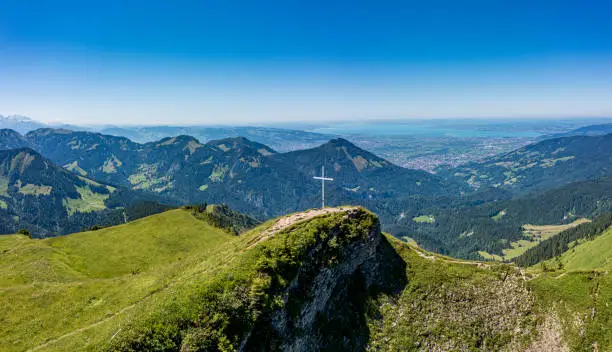 Summit cross on a mountain (Moerzelspitze) with Lake of Constance in the background