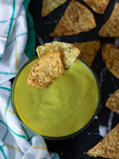 istock Vegan cheese sauce dip in a bowl with crispy corn chips on dark background, top view 1440569163