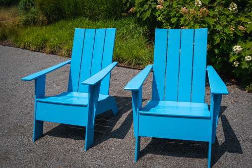 Two blue Adirondack chairs in the garden