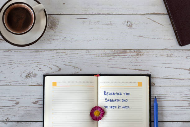 istock Sabbath Day rest handwritten text in open notebook with Holy Bible Book and coffee cup on wooden background, top view, copy space 1440569998