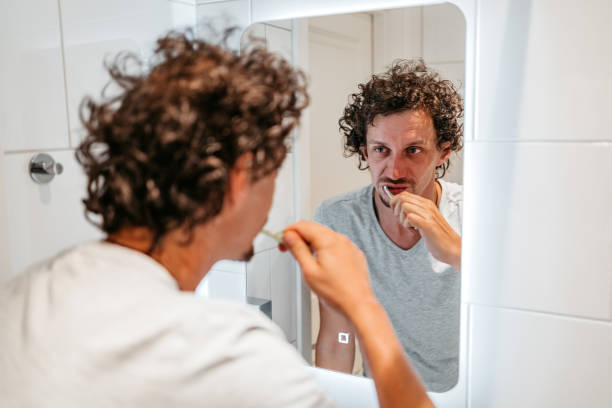istock Young Man Brushing Teeth In The Bathroom In Morning 1440570636