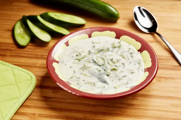 Cucumber yogurt raita served in bowl isolated on table side view of middle east food