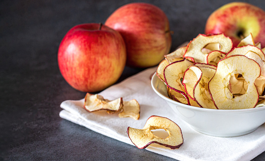 Bowl of dried organic apple sliced chips. Healthy snacks concept