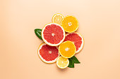 Slices of citrus fruits laid out on a beige background