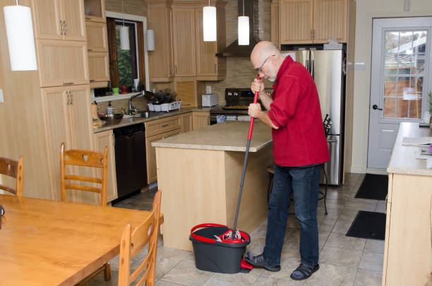 istock Mature man washing kitchen floor with mop 1440573621