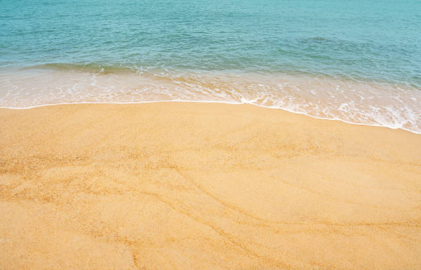 spiaggia di sabbia e oceano blu con forma d'onda morbida sulla trama della sabbia, vista sul mare della duna di sabbia di brown beach in una giornata di sole in primavera, vista dall'alto holizontal per lo sfondo dello striscione estivo. - holizontal foto e immagini stock