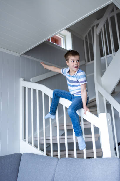 istock Boy sliding on the staircase in the house 1440574245