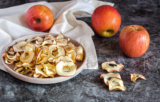Homemade dried organic apple sliced chips in bowl. Healthy snacks concept
