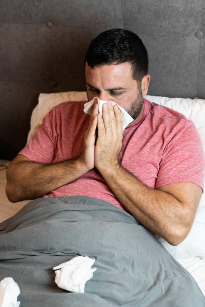 istock Middle-aged man in bed sick with flu symptoms 1440575564