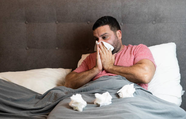 istock Middle-aged man in bed sick with flu symptoms 1440575606