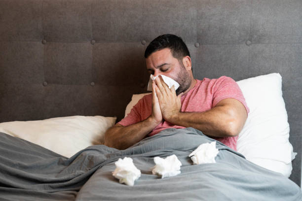 istock Middle-aged man in bed sick with flu symptoms 1440575621