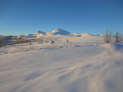Beautiful view of a snow covered landscape in Tuddal, Norway, with Gaustatoppen in the background. Gaustatoppen is Telemarks highest mountain.