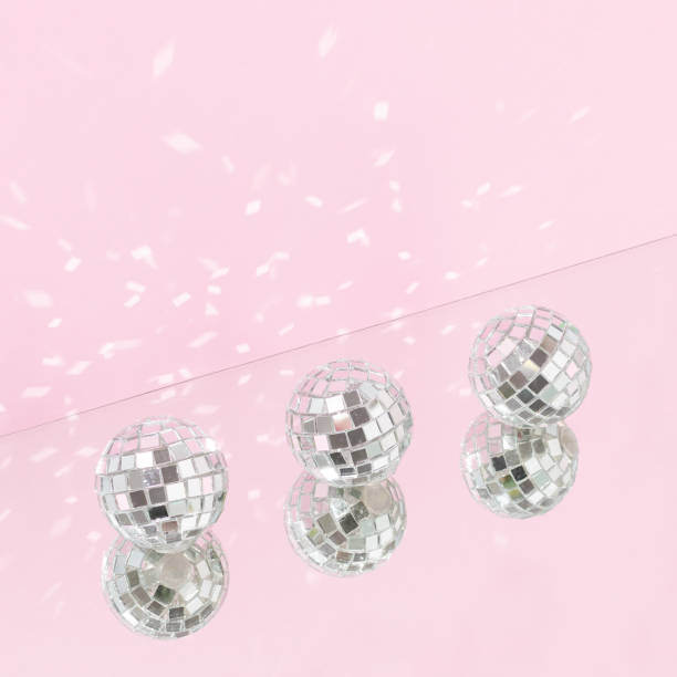 istock Three shiny disco balls with mirror reflection against bright pink background. Minimal holidays celebration party creative concept. Retro 80s or 90s disco aesthetic. 1440579737