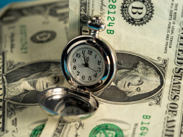 istock Old pocket watches lie on dollar bills. 1440579756