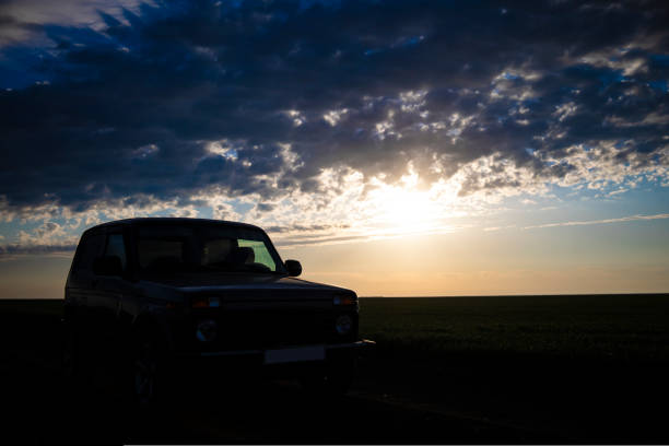 istock A car at sunset or dawn in a field. 1440580696