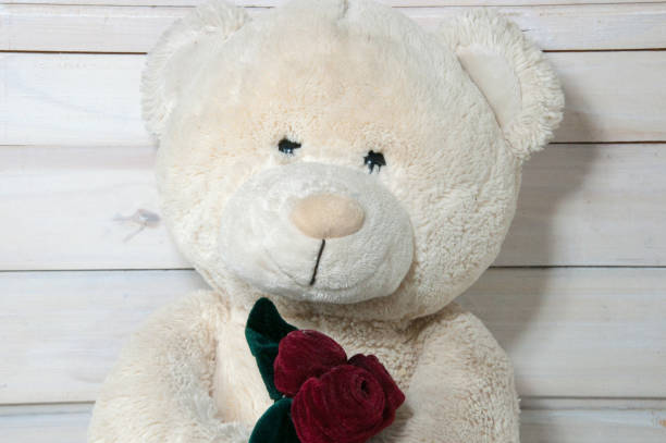 istock teddy bear with a red bow on a wooden background 1440581313