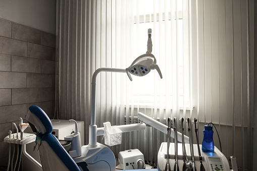 Professional stomatological equipment for doctor in dentist office. Cozy dental room in new modern stomatological clinic. Background of chair, accessories used by dentists in medic light. Copy space