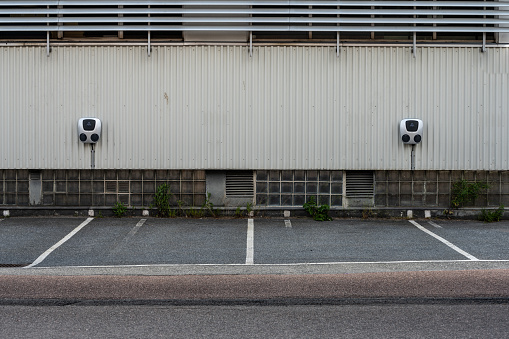 Gothenburg, Sweden - June 25 2022: Two wall mounted electric car chargers serving four parking slots.