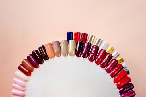 Nail polish samples in different bright colors. Colorful nail lacquer manicure swatches. Top view of nail art wheel palette.