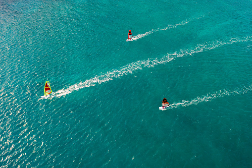 Areal view of group of wind surfers crossing blue coastal water at full speed, Vasiliki, Lefkada Island