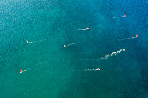 Areal view of group of wind surfers crossing blue coastal zone at full speed, Vasiliki, Lefkada Island