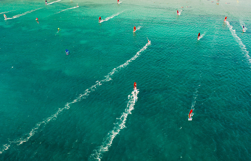 Areal view of group of wind surfers rushing through blue coastal zone at full speed, Vasiliki, Lefkada Island