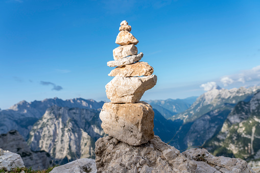 Stack of stones in front view, in backgrounds view from high mountains down to valley Trenta, Julian Alps, Slovenia