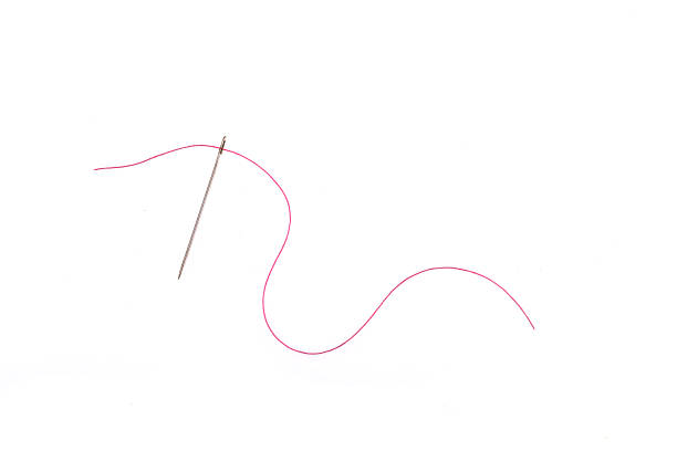istock needle and thread of red color on a white background 1440595121