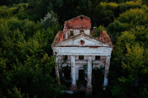 istock Old ruined overgrown abandoned mansion, aerial view. 1440595129