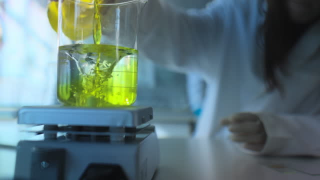 Liquid in a beaker on magnetic stirrer in laboratory.