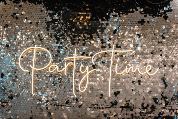 istock Silver photo booth with decor shiny and led strips with text party time. Zone with sparkling sequins. Glittery festive wall for wedding. A place for congratulations on birthday. Happy New Year 2023. 1440596421
