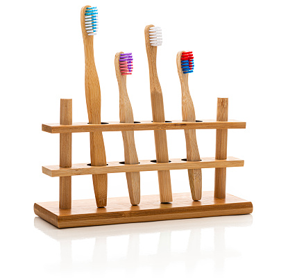 Bamboo toothbrushes in a holder.  
Isolated on white.