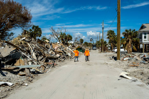 operai che camminano lungo cumuli di detriti vicino a estero blvd - fort myers foto e immagini stock