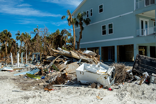 Fort Myers Beach, Florida - October 26, 2022: Debris sitting next to a house that was damaged during Hurricane Ian