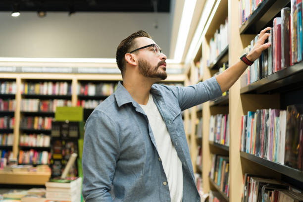 istock Smart man at the bookstore looking for a book or novel 1440606786