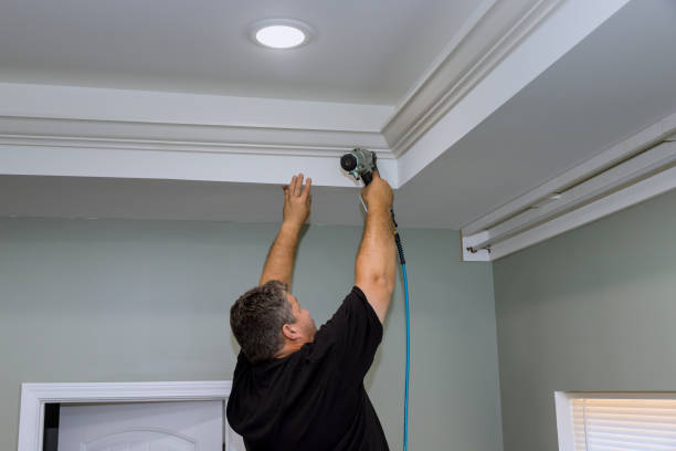 istock A professional carpenter nails wood crown molding between a newly constructed home's ceiling and the wall, using an air pneumatic nail gun 1440607998