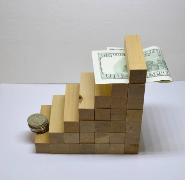 istock wooden growth steps with coins and paper dollars on white background 1440610638