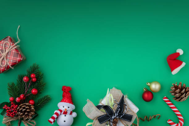 istock Christmas background with gift boxes, festive decorations, fir tree branch and pine cones on green paper. 1440611887