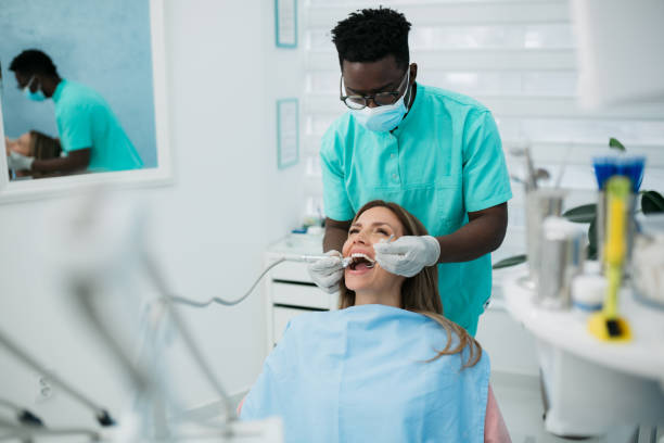 istock A professional dentist carefully working with his female patient 1440612327
