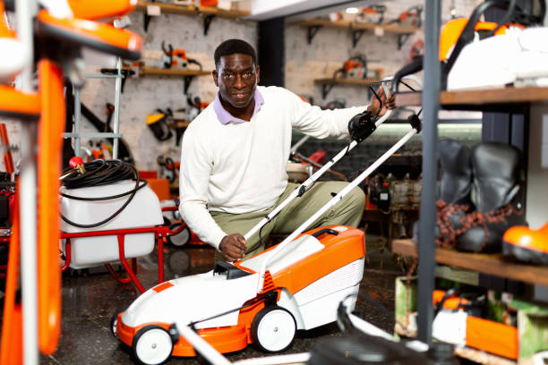 African-american man choosing grass-mower in gardening tools store.