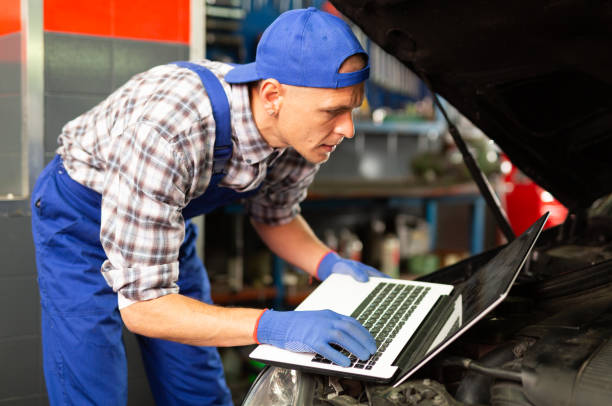 istock Mechanic with laptop near car engine in auto service 1440612966