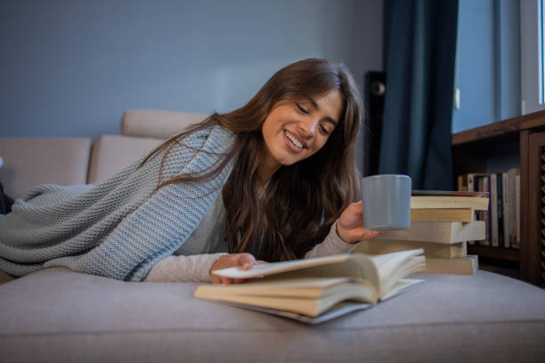 istock Happy woman reading book at home 1440614539