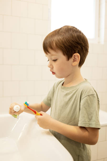 istock 5 year old boy brushing his teeth with a toothbrush in a home bathroom 1440614718