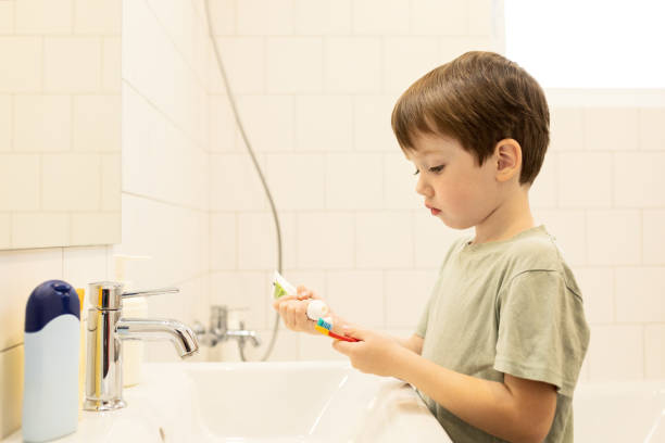 istock 5 year old boy brushing his teeth with a toothbrush in a home bathroom 1440614726