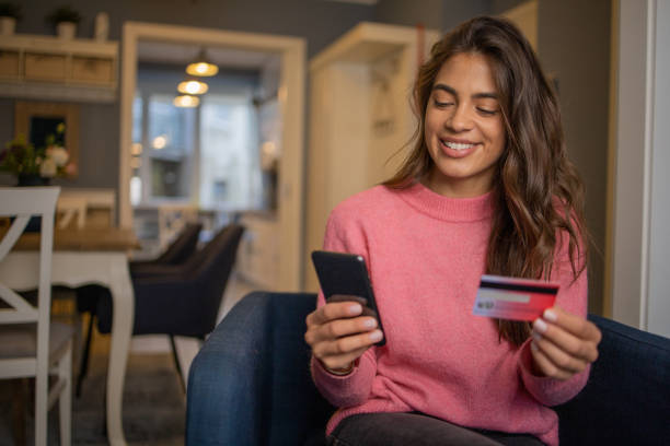 istock Cheerful  woman doing online shopping 1440616207
