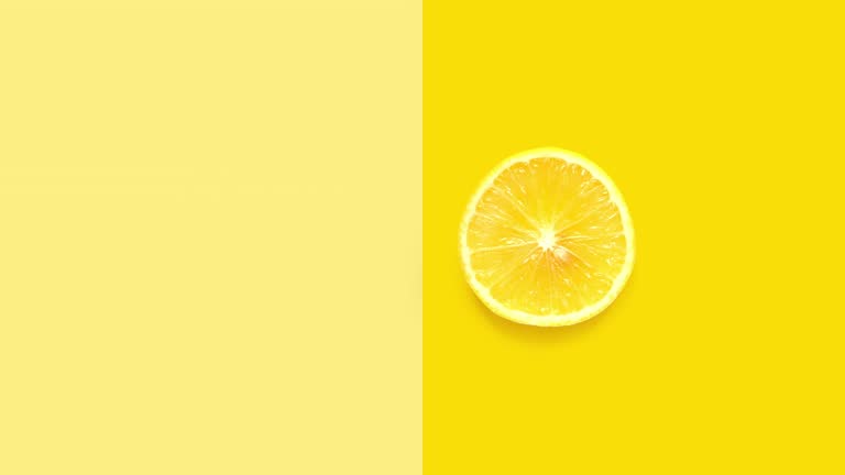 Creative animation made of lemon full an peeled on the yellow background. The concept of food.