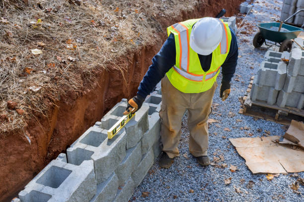 istock Levelling tool used by a man during the construction of a retaining concrete block wall on a new property 1440624876