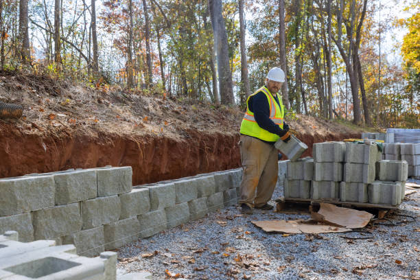 istock A man uses a leveling tool during the construction of a concrete block wall to create a retaining wall on a new property 1440624877