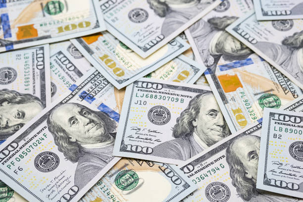 istock One hundred dollar bills. U.S. paper currency background. 1440625747