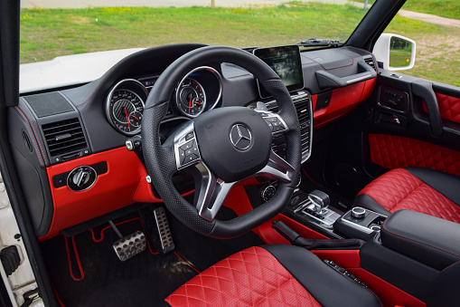 Berlin, Germany - 18th August, 2018: Interior in luxurious Mercedes-AMG G63. This car is one of the most luxury SUV vehicles in the world. Focus on a steering wheel.
